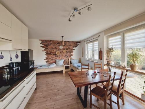 a kitchen and living room with a wooden table and chairs at Ferienwohnung Sunny in Mittenwalde