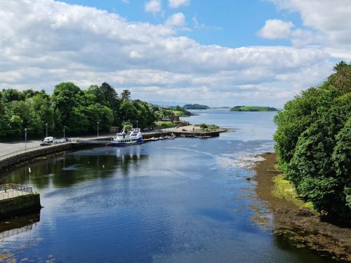 a river with a boat docked at a dock at Central Hotel Donegal in Donegal