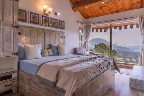 a bedroom with a large bed with a large window at SaffronStays Farsouli 1° in Bhowāli