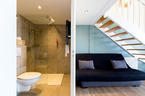a bathroom with a toilet and a staircase at Les Lofts du Grand Lac de Lozère in Langogne