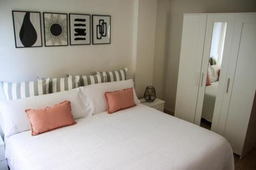 a bedroom with a white bed with two pink pillows at MI CAPRICHO in Santa Cruz de la Palma