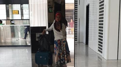 a woman standing in an airport with her luggage at Osaka Hotel Batam in Nagoya