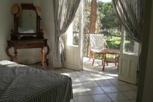 a bedroom with a bed and a mirror and a porch at Villa Aurelia, 70m from the sea in Santa Margherita di Pula