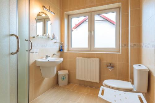 a bathroom with a toilet and a sink and a window at Hotel Diament in Grzybowo