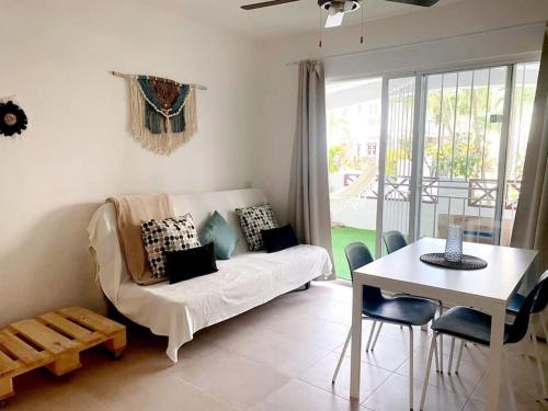 uma sala de estar com um sofá e uma mesa em Xarraca em Bayahibe