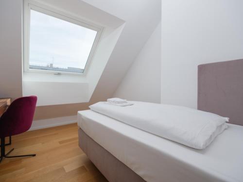 a white bedroom with a bed and a window at MyFavorit Apartments - Spacious Apartments next to Puplic Transport U1 direct connection to Citycenter in Vienna