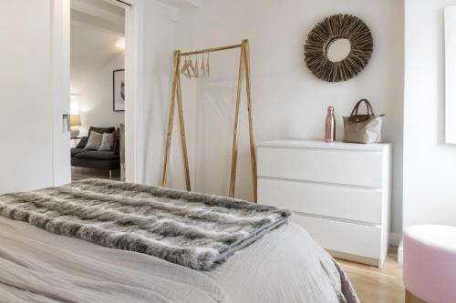 - une chambre blanche avec un lit et un miroir dans l'établissement Romantic Nest for a Getaway with Design & Free Parking, à Lisbonne