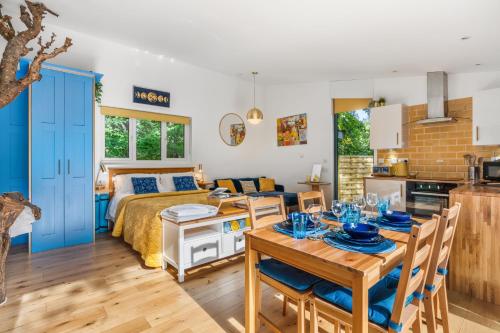 a bedroom with a bed and a dining room with a table at Ivy Cottage Holiday Cabins in Southampton