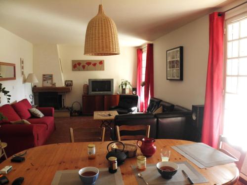 ein Wohnzimmer mit Tisch und Couch in der Unterkunft Gîte en Ardèche Méridionale - Les Berbéris in Chandolas