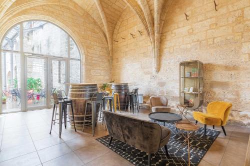 a room with tables and chairs and a large window at Appart'City Classic Angoulême Centre in Angoulême