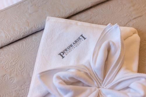 a white package with a napkin on top of a bed at APARTAMENTY Słowackiego 5b, Karpacz in Karpacz