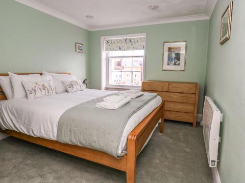 Un dormitorio con una cama grande y una ventana en Embassy en Weymouth