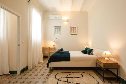 a white bedroom with a bed and a window at Alleanza, Aires de Guadalquivir in Seville