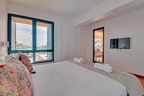 a bedroom with a large bed and a large window at GARDEN MARINA in Vilamoura