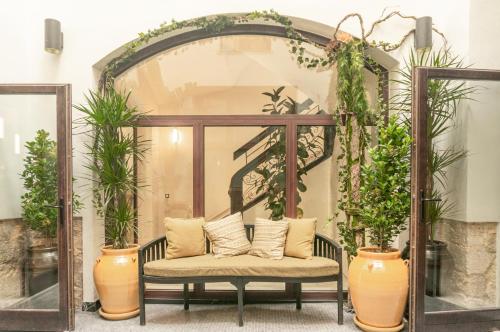 a bench in a room with potted plants at The Valentia Corretgería in Valencia