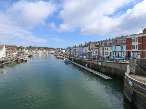 a view of a river with boats in a town at Monarch in Weymouth