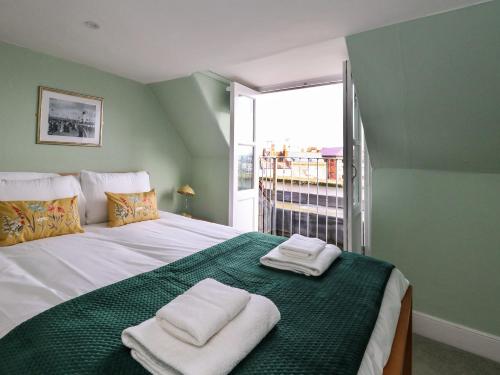 a bedroom with a large bed with towels on it at Monarch in Weymouth