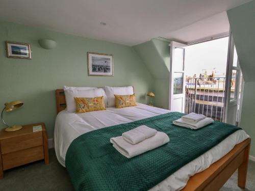 a bedroom with a large bed with towels on it at Monarch in Weymouth