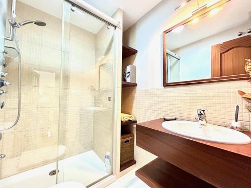 a bathroom with a glass shower and a sink at Hispalis Triana in Seville