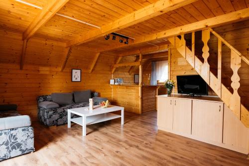 a living room with a couch and a tv at Domki Bałtyckie in Władysławowo