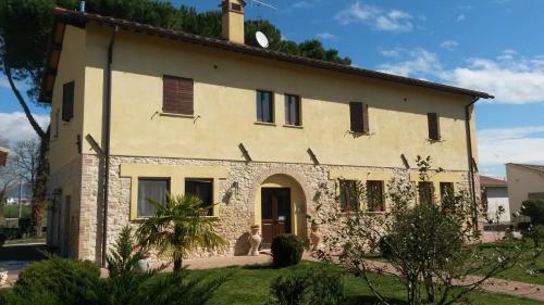 an old stone house with two cats sitting in front of it at Casale Malva in Narni