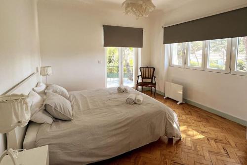 - une chambre dotée d'un grand lit avec deux chaussures dans l'établissement Banzão home PineForest family &friends pool garden, à Colares
