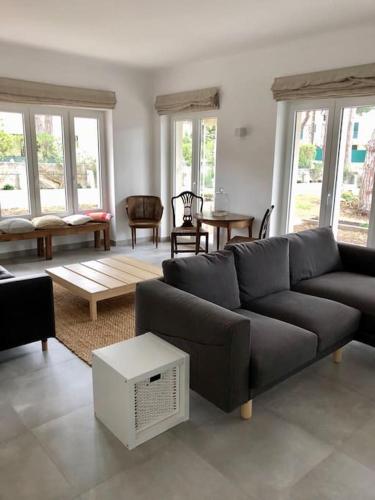 a living room with a couch and a table at Banzão home PineForest family &friends pool garden in Colares
