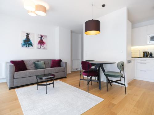 a living room with a couch and a table and chairs at MyFavorit Apartments - Spacious Apartments next to Puplic Transport U1 direct connection to Citycenter in Vienna