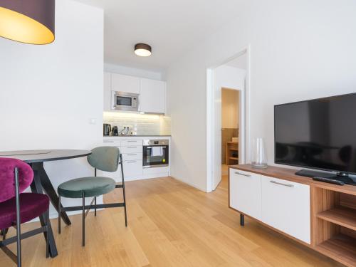 a living room with a dining room table and a television at MyFavorit Apartments - Spacious Apartments next to Puplic Transport U1 direct connection to Citycenter in Vienna