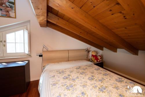 Schlafzimmer mit einem Bett und Holzdecken in der Unterkunft Villa San Martino in San Martino della Battaglia