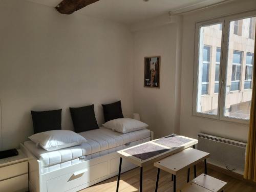 Zimmer mit einem Bett, einem Fenster und einem Tisch in der Unterkunft Studio sur le port de Toulon in Toulon
