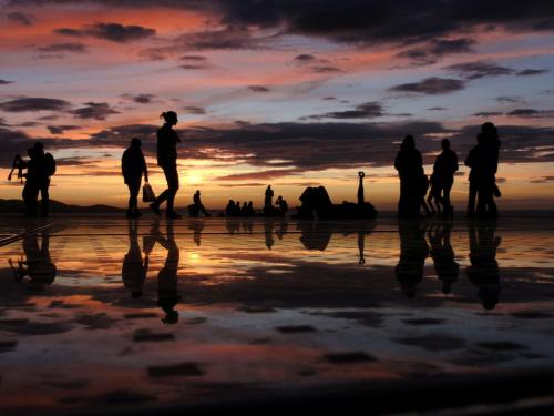 Eine Gruppe von Menschen, die bei Sonnenuntergang am Strand spazieren gehen in der Unterkunft Apartment Roxy in Zadar