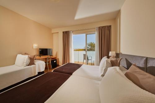 um quarto de hotel com duas camas e uma varanda em Sercotel Hotel Zurbarán Palma em Palma de Maiorca