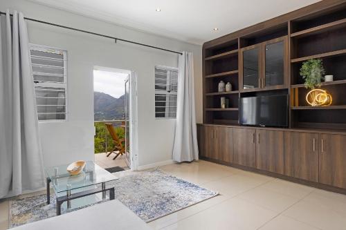 a living room with a tv and a glass table at Mount Bay in Hout Bay