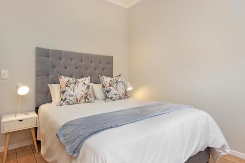 a bedroom with a large bed with white sheets and pillows at Mount Bay in Hout Bay