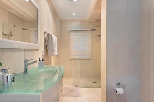 a bathroom with a green sink and a shower at Mount Bay in Hout Bay