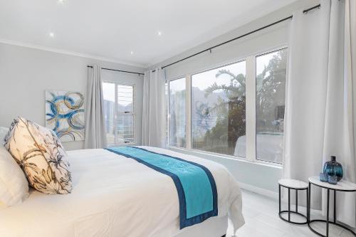 a bedroom with a bed and a large window at Mount Bay in Hout Bay