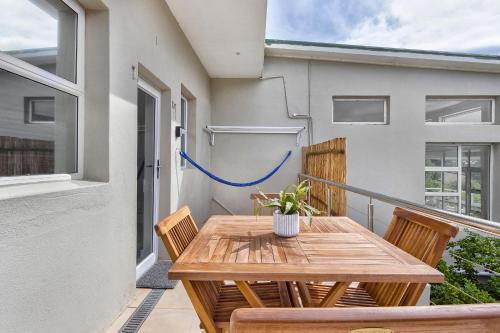 a wooden table and chairs on a balcony at Mount Bay in Hout Bay
