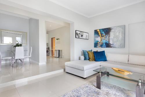 a living room with a white couch and a table at Mount Bay in Hout Bay