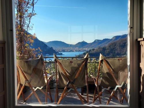 ein paar Stühle auf einer Veranda mit Aussicht in der Unterkunft Casa Santo Stefano in Cernobbio