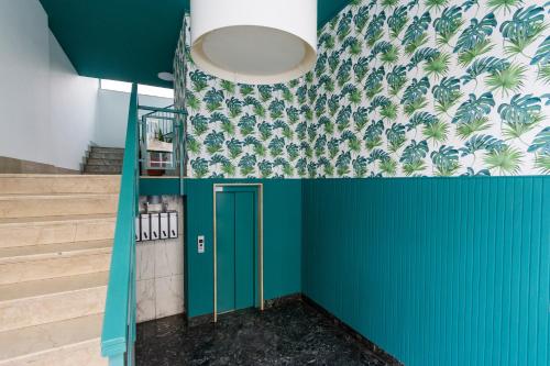a hallway with green walls and a blue door at AlbaResidence Vico01 in Alba