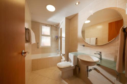 uma casa de banho com um lavatório, um WC e um espelho. em Sercotel Hotel Zurbarán Palma em Palma de Maiorca
