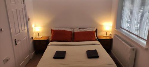 a small bedroom with a bed with two lamps on it at Birds Nest - Surrey Quays in London