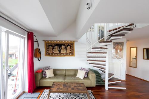 uma sala de estar com um sofá e uma escada em espiral em The Beverly Hills of Frankfurt in Hofheim Penthouse or Garden em Hofheim