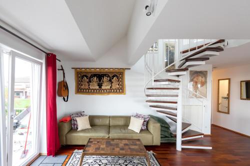 a living room with a couch and a spiral staircase at The Beverly Hills of Frankfurt in Hofheim Penthouse or Garden in Hofheim am Taunus