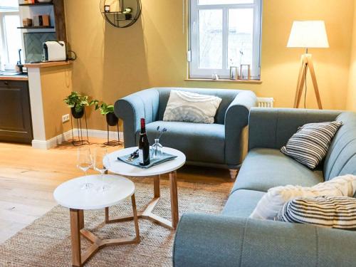 un soggiorno con divano blu e 2 tavoli di Ferienhaus Altstadtchalet a Schmallenberg