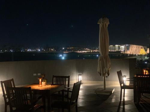a patio with a table and a umbrella at night at Locanda Museum Hotel in Giza
