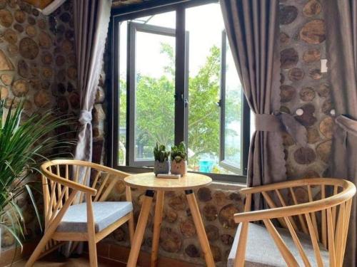 a table and two chairs in front of a window at Cau May Tam Dao - Venuestay in Tam Ðảo