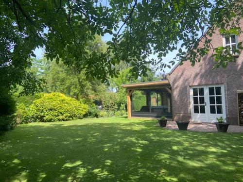una casa con un cortile verde con una casa di Het Blij Hoen a Oudenbosch