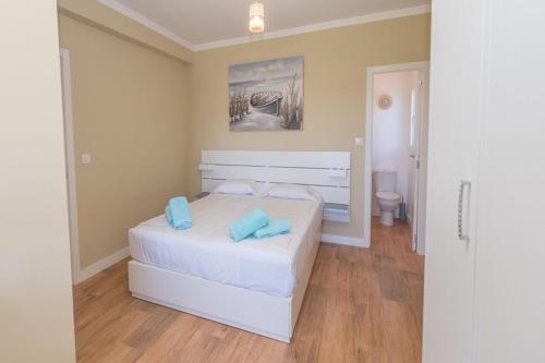 een slaapkamer met een wit bed en een toilet bij Villa Leonie, private pool, jacuzzi, 8p in Orba
